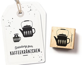 Puede incluir: Dos etiquetas blancas con una ilustración negra de una tetera y una taza, con el texto "Einladung zum KAFFEEKRÄNZCHEN". También hay un sello de madera con el mismo diseño de tetera.
