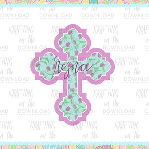 Puede incluir: Una cruz rosa con un patr&oacute;n floral azul claro y la palabra "Regocijaos" escrita en cursiva.