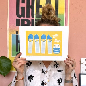 May include: A yellow print with a blue and white illustration of five eggs with the text "Dip Dip" and "Eggs for Dip".