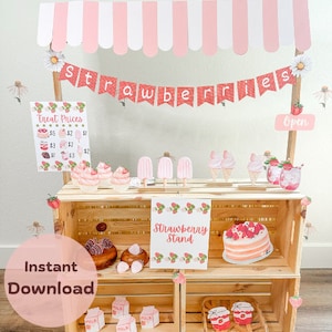May include: A wooden strawberry stand with a pink and white striped awning. The stand is decorated with strawberry-themed decorations, including a banner that says "strawberries", a sign that says "Strawberry Stand", and various strawberry-themed treats. The stand has three shelves, and the top shelf has a sign that says "Treat Prices" with prices listed for various treats. The stand is set up for a party or event.