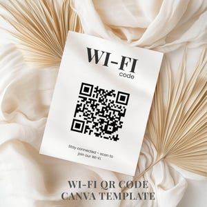 Pode incluir: Um cartão branco com o texto "WI-FI code" e um código QR preto. O cartão está sobre um tecido creme com folhas de palmeira secas. O texto "Stay connected - scan to join our Wi-Fi" está abaixo.