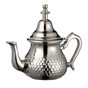 May include: A polished silver teapot with a distinctive design. The teapot has a curved spout, a handle, and a lid with a decorative finial. The body of the teapot has a textured, dimpled pattern.
