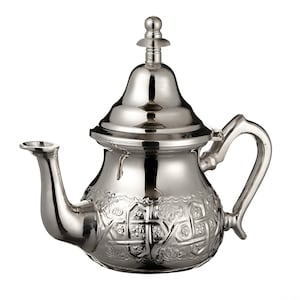 May include: A shiny silver teapot with an ornate floral and geometric design. It features a curved spout, a curved handle, and a domed lid with a small finial. The teapot is designed for serving tea, a traditional item.