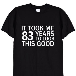 May include: Black t-shirt with white text that reads "It took me 83 years to look this good."