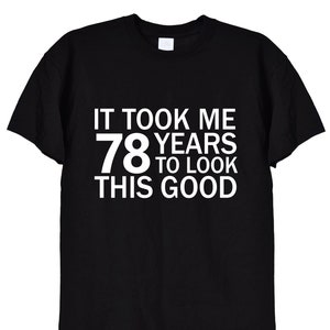 May include: Black t-shirt with white text that reads "It took me 78 years to look this good."