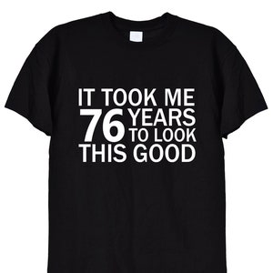 May include: Black t-shirt with white text that reads "It took me 76 years to look this good."