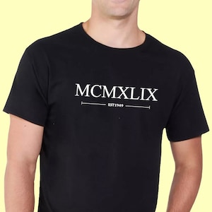 May include: A black t-shirt with white text that reads "MCMXLIX EST 1969".