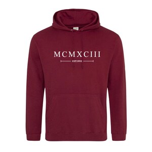 K&ouml;nnte beinhalten: Ein weinroter Kapuzenpullover mit dem Aufdruck "MCMXCIII EST 1993" in Wei&szlig; auf der Vorderseite.