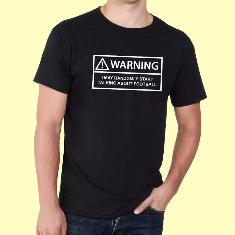 May include: Black t-shirt with a white warning sign that says "WARNING I MAY RANDOMLY START TALKING ABOUT FOOTBALL"