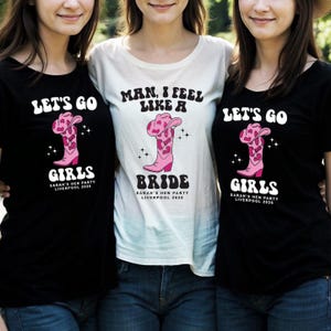 May include: Three black and white t-shirts with a pink cowboy boot graphic and text that reads "Let's Go Girls", "Man, I Feel Like a Bride", and "Let's Go Girls".