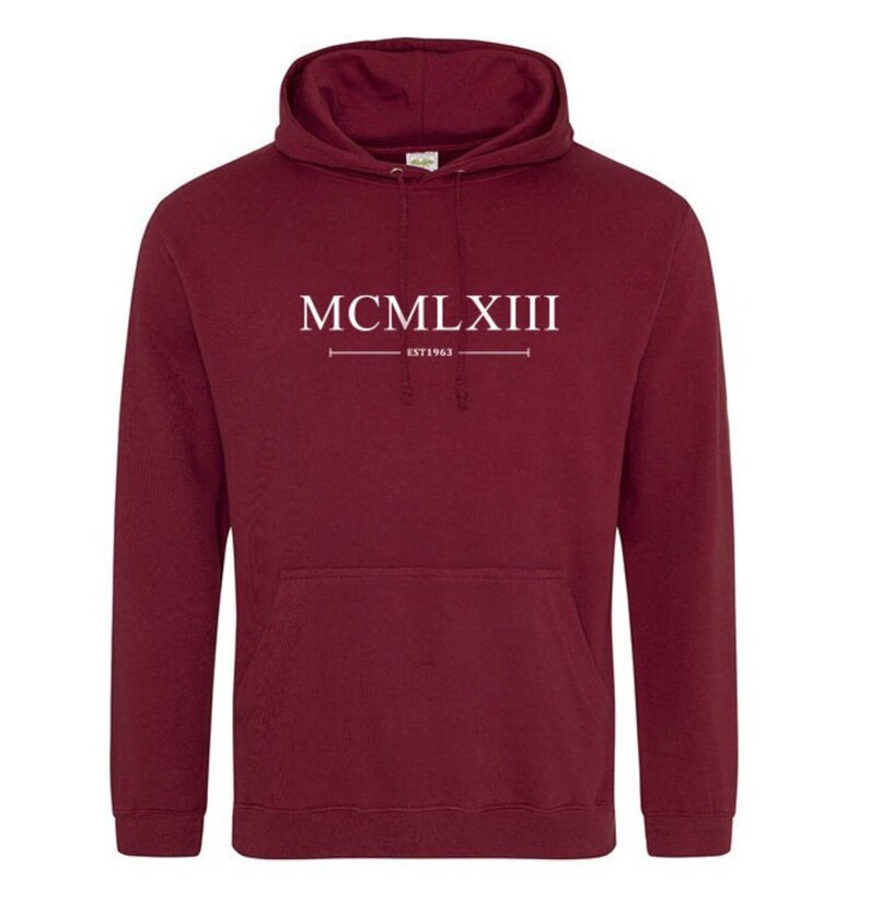 Puede incluir: Sudadera con capucha color burdeos con texto blanco que dice "MCMLXIII EST 1963".