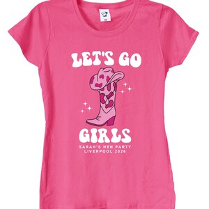 May include: Pink t-shirt with the text "Let's Go Girls" in white with a pink cowboy boot graphic and the text "Sarah's Hen Party Liverpool 2026".