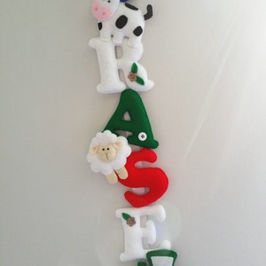 May include: A felt banner with the word "FARMER" spelled out in colorful letters. Each letter has a different farm animal or farm-themed image attached to it. The letters are blue, white, green, red, white, and blue.
