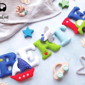 May include: Felt letter banner spelling out the name "BERKLEY" with various colorful felt embellishments including a sailboat, airplane, car, and stars.