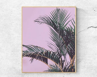 May include: A framed print of a palm tree with green leaves against a light pink background.