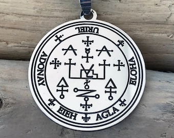 May include: Silver pendant with a black leather cord. The pendant features a circle with a black and white design and the words "URIEL", "ADONAY", "EIEH", "AGLA", "ELOHIA" around the edge.