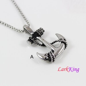 May include: A silver anchor pendant necklace with black rope detailing. The anchor is a classic nautical design and the necklace is a great way to show your love for the sea.