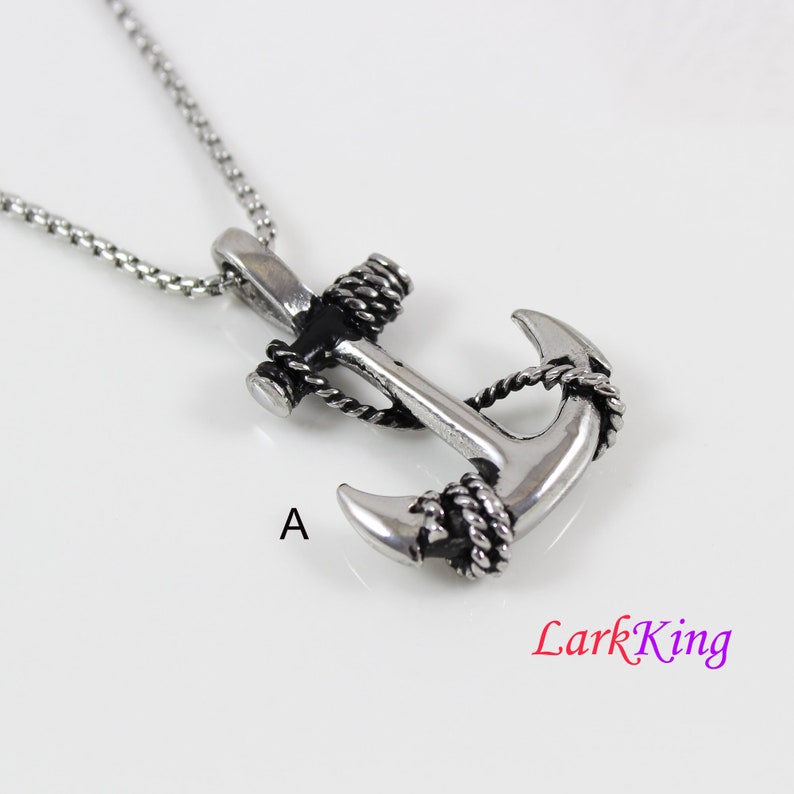 May include: A silver anchor pendant necklace with black rope detailing. The anchor is a classic nautical design and the necklace is a great way to show your love for the sea.
