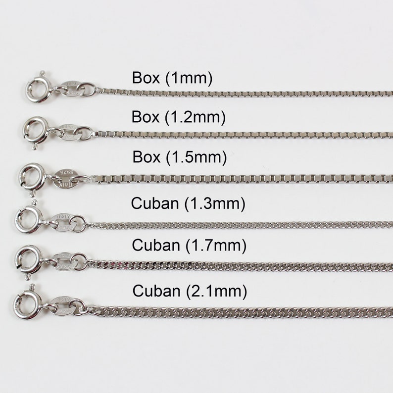 May include: Six silver chains of different widths and styles, labelled with their names and measurements in millimetres. The chains are arranged in rows from top to bottom, with the smallest chain at the top and the largest chain at the bottom. The chains are all made of silver and have a polished finish.
