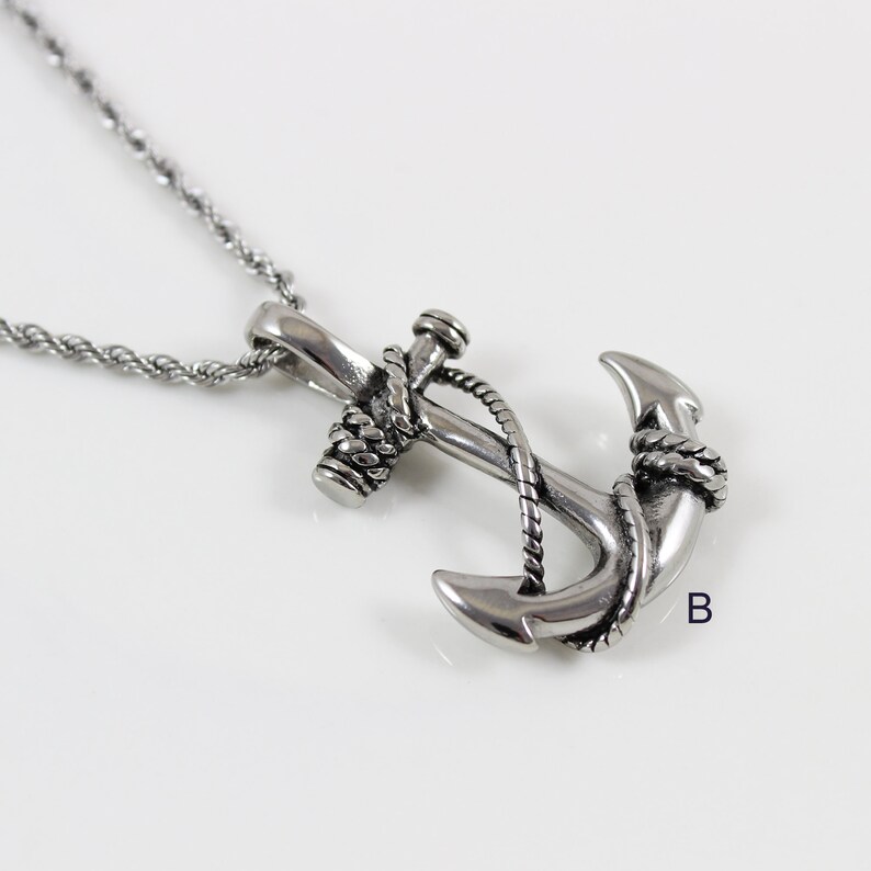 May include: A silver anchor pendant necklace with a rope design. The anchor is detailed with a rope wrapped around the top and the arms.