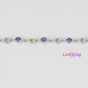 May include: A silver bracelet with a heart-shaped design and purple gemstones.