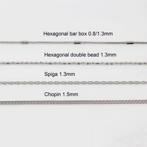 May include: Four different types of silver chains are displayed on a white background. The chains are labelled with their names and sizes: Hexagonal bar box 0.8/1.3mm, Hexagonal double bead 1.3mm, Spiga 1.3mm, and Chopin 1.5mm.