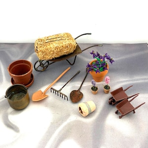 May include: A miniature gardening set featuring a metal wheelbarrow with a hay bale, two brown plastic wheelbarrows, a terracotta pot, a metal pot, a shovel, a rake, a trowel, a small beige bucket, and three potted artificial flower plants.