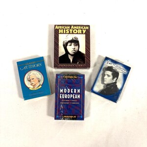 Puede incluir: Se muestran cuatro barajas de cartas. Una es azul con "Classic Authors" y un retrato de Mark Twain. Otra es "African American History". La tercera es "Modern European". La cuarta presenta un retrato de Elvis Presley. Las medidas no son aplicables.