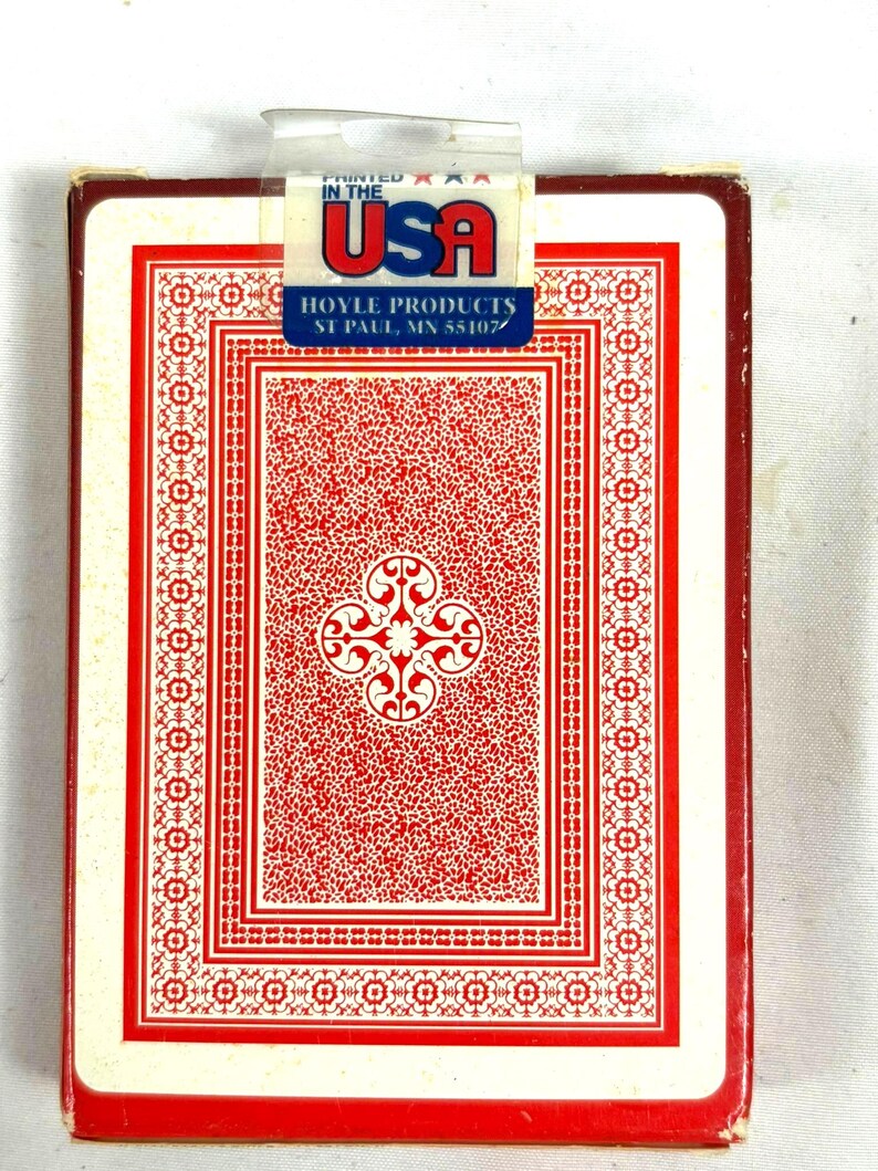 Puede incluir: Una baraja de cartas Hoyle, impresa en EE. UU. El dorso de la carta presenta un dise&ntilde;o rojo y blanco con un motivo floral central y un borde decorativo. La caja es roja y blanca.