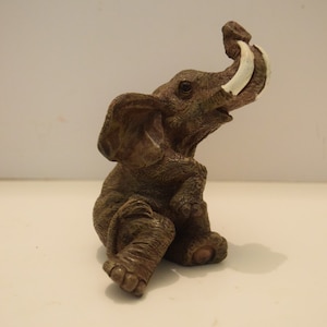 I fell and I can’t get up! Resin Elephants White Tusks Sitting Elephant with Tusk Figurine