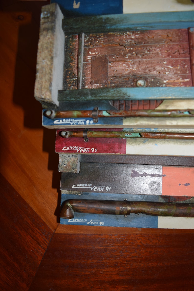 May include: Close-up of a stack of wooden boards with copper pipes and the text "CARUBIA VERA 90" and "CARUBIA VERA 91" written on them.
