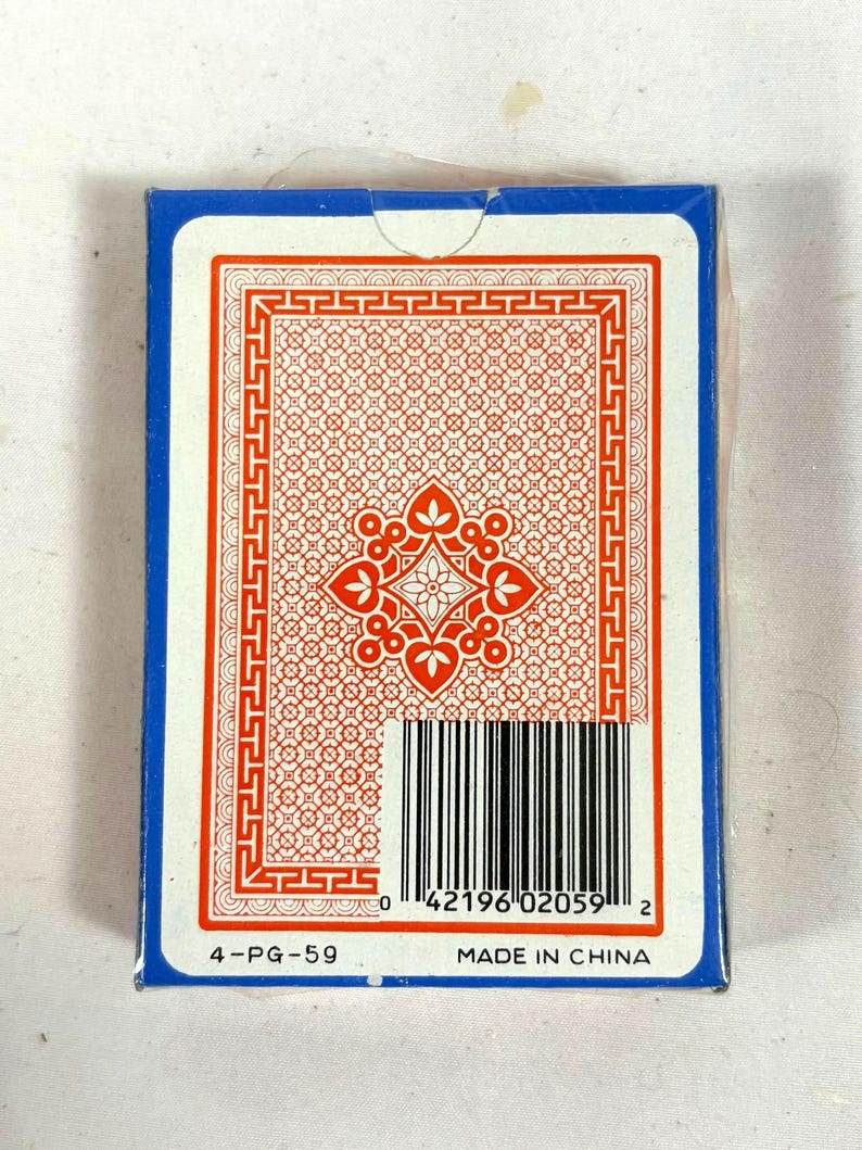 Puede incluir: Un mazo de naipes en una caja azul. El dorso de las cartas presenta un dise&ntilde;o floral rojo y blanco con un borde decorativo. La caja tiene un c&oacute;digo de barras y el texto "MADE IN CHINA".