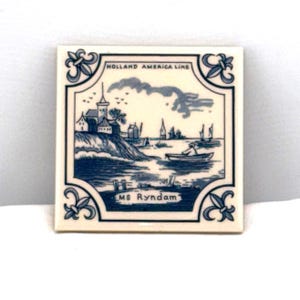 May include: Square ceramic tile with a blue and white nautical scene. The image depicts a coastal landscape with buildings, boats, and a cloudy sky. The tile is framed with decorative floral elements and text that reads "HOLLAND AMERICA LINE" and "MS RYNDAM."