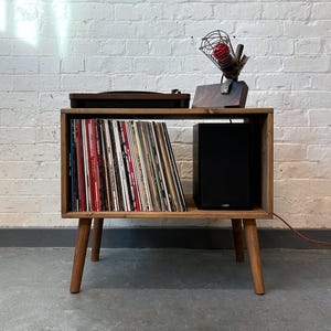 70 cm wide mid century style wooden record player stand in a medium finish.