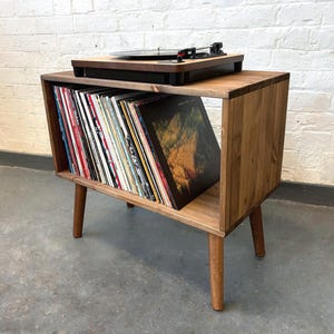 70 cm wide mid century style wooden record player stand in a medium finish.