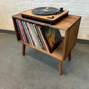 70 cm wide mid century style wooden record player stand in a medium finish.