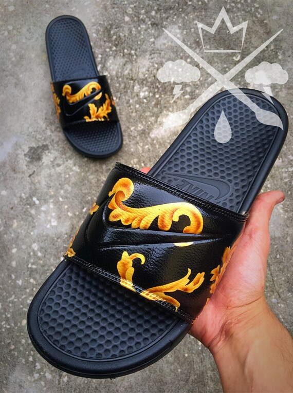 black nike slides with gold swoosh