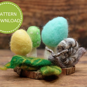 May include: A felt mushroom forest scene with a snail, a green leaf, and a wooden base. The mushrooms are yellow, green, and blue.