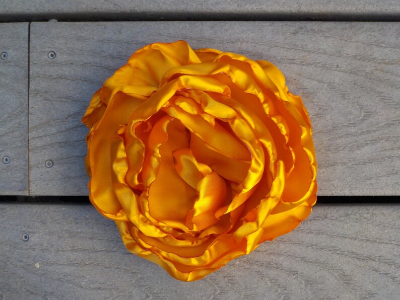 May include: A large, bright yellow silk flower with multiple layers of petals.