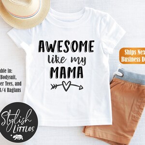 Op de afbeelding: Wit T-shirt met zwarte tekst die "AWESOME like my MAMA" luidt, met een pijl- en hartvormig motief. *Beschikbaar in: Baby-romper, peuter-T-shirts en kinder-3/4-raglans. Stylish LITTLES.