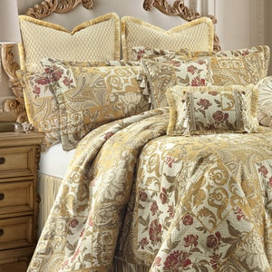 May include: A gold and cream patterned quilt set with a floral design. The set includes a quilt, two pillow shams, and three decorative pillows.