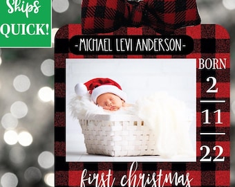 May include: Red and black buffalo plaid Christmas ornament with a photo of a baby in a white basket. The ornament also includes the text "Michael Levi Anderson" and "Born 2-11-22" and "first christmas".