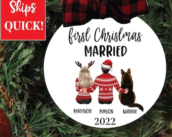 May include: White round Christmas ornament with the text "first Christmas married" and the year 2022.  The ornament features a cartoon illustration of a couple in red and white sweaters with a dog.  The names Madison, Mason, and Winnie are printed below the couple and dog.