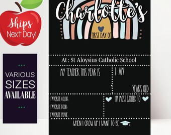 May include: A black chalkboard with a rainbow and the text "Charlotte's First Day Of" at the top. The chalkboard is divided into sections with labels such as "My Teacher This Year Is", "Years Old", "I'm Most Excited To", "Favorite Color", "Favorite Food", "Favorite Movie", and "When I Grow Up I Want To Be".