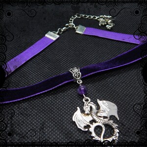 May include: A purple velvet choker necklace with a silver dragon pendant and a purple amethyst bead. The necklace has a silver chain extender.