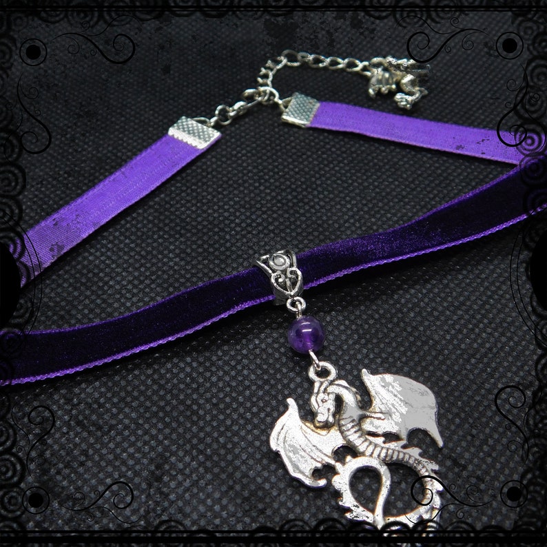 May include: A purple velvet choker necklace with a silver dragon pendant and a purple amethyst bead. The necklace has a silver chain extender.
