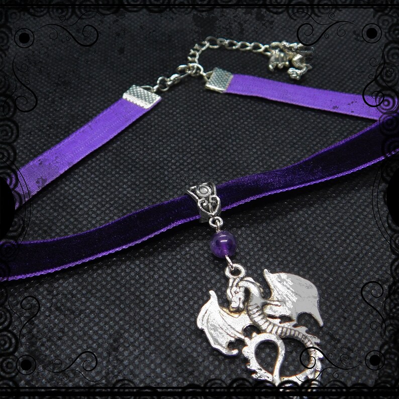 May include: A purple velvet choker necklace with a silver dragon pendant and a purple amethyst bead. The necklace has a silver chain extender.