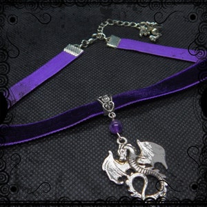 May include: A purple velvet choker necklace with a silver dragon pendant and a purple amethyst bead. The necklace has a silver chain and clasp.