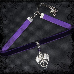 May include: A purple velvet choker necklace with a silver dragon pendant and a smaller silver dragon charm on a silver chain.
