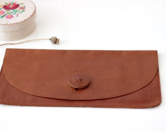 Simple leather case, clutch, document holder made of reddish leather, with button closure and inner pockets